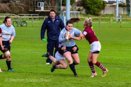 Hannah Heskin looks to break a Tullow RFC tackle on the wing, while coach Eddie Fallon shouts orders from the sideline. Photo: Stephen Kisbey-Green